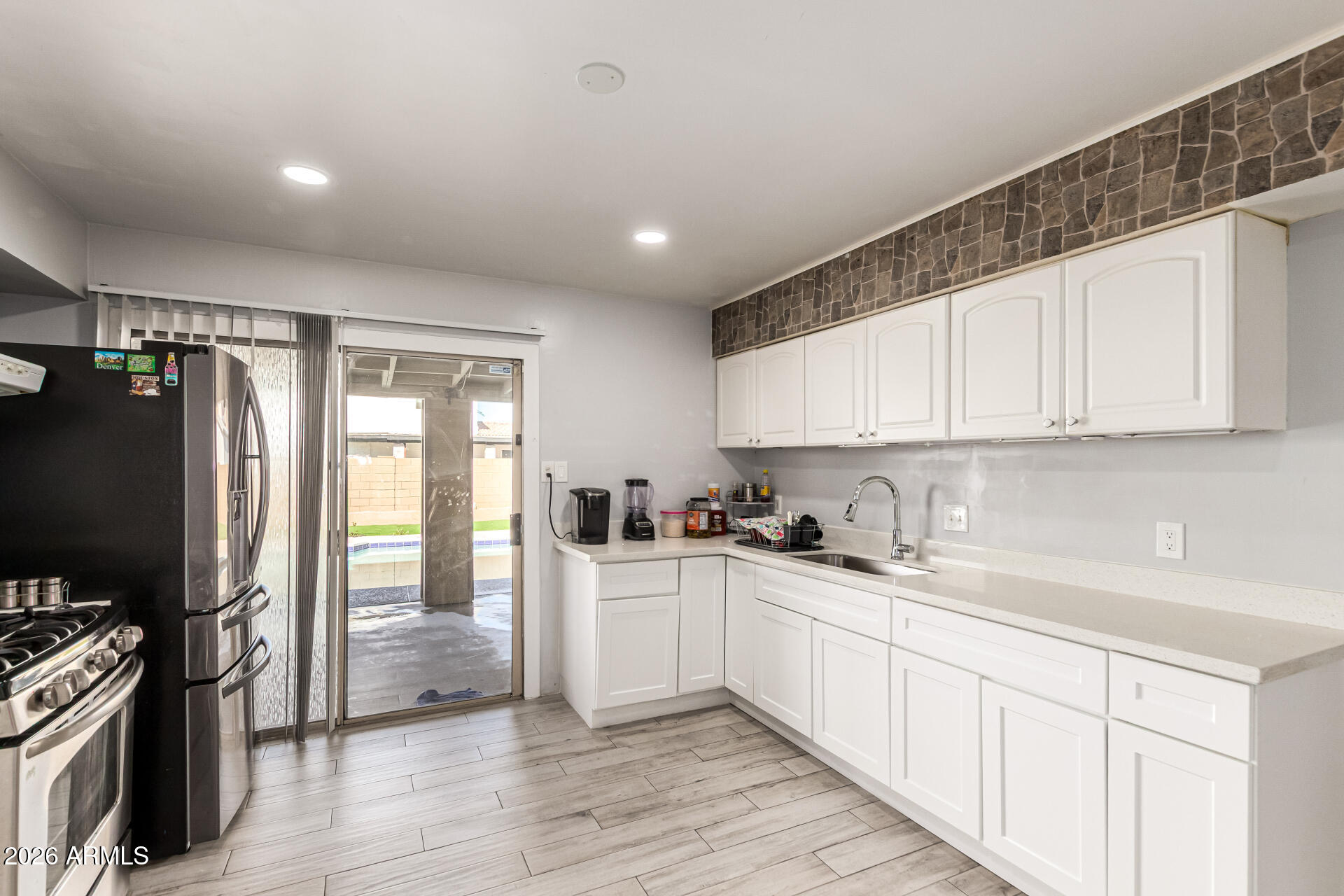 8218 West Osborn Road Phoenix, AZ 85033 - Photo 9 of 27 a kitchen with stainless steel appliances a sink stove refrigerator and cabinets