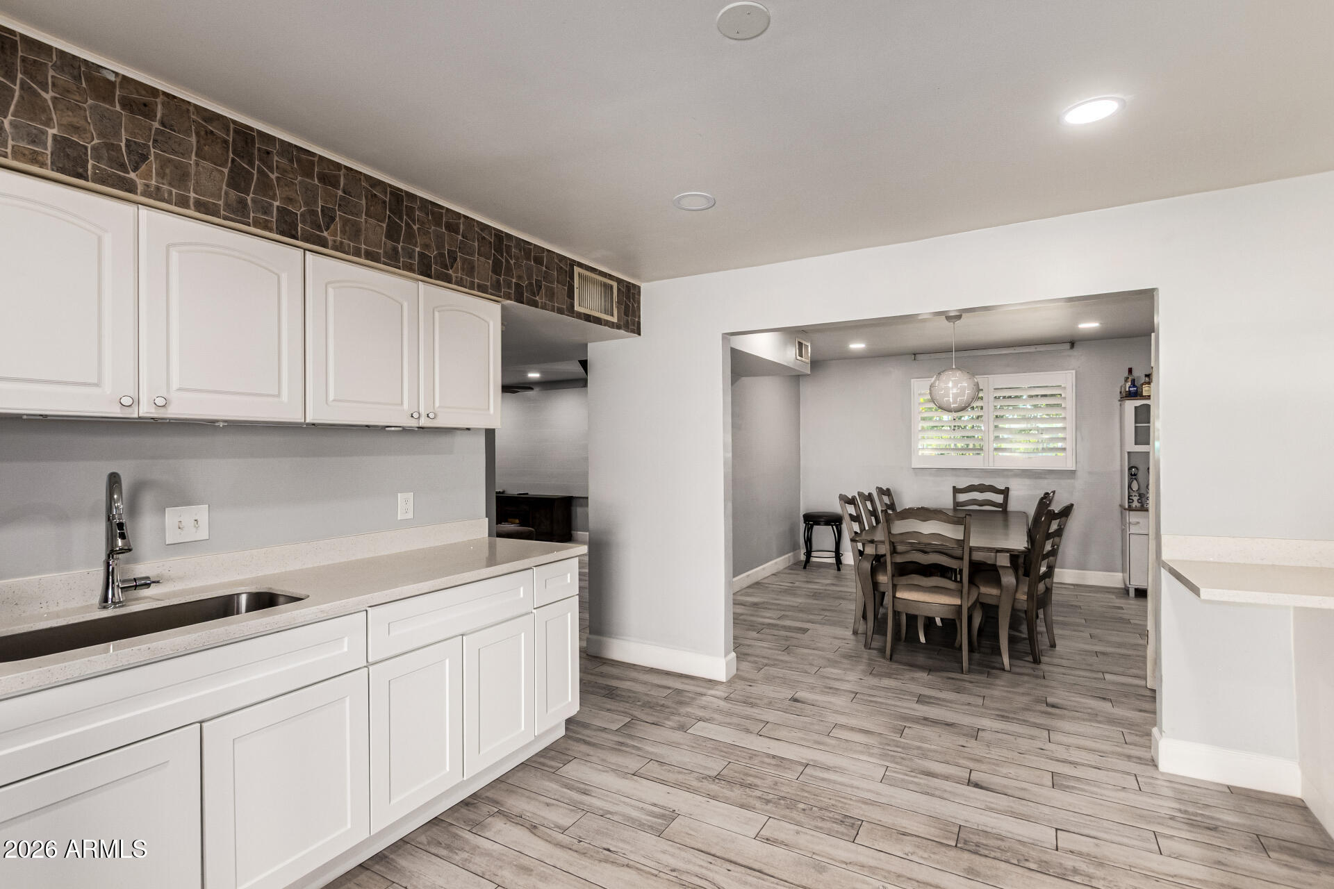8218 West Osborn Road Phoenix, AZ 85033 - Photo 10 of 27 a kitchen with white cabinets and dining table chair
