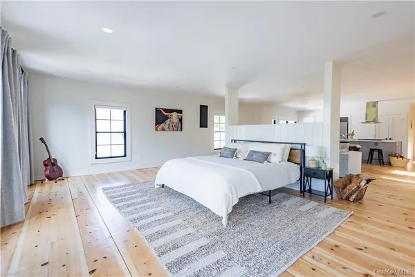 a spacious bedroom with a bed a table and chair