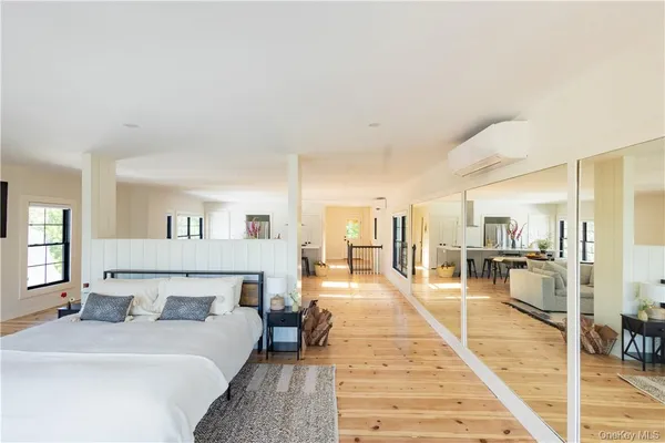 a large bedroom with a bed and a view of living room