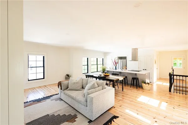 a living room with furniture and a dining table with rug