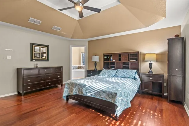 a bedroom with a bed and wooden floor