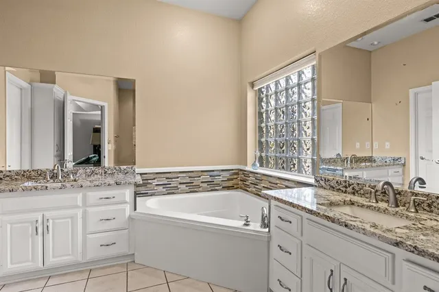 a bathroom with a granite countertop sink and a bathtub