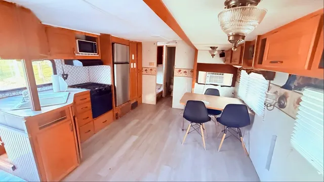 a dining room with wooden floor a glass table and chairs