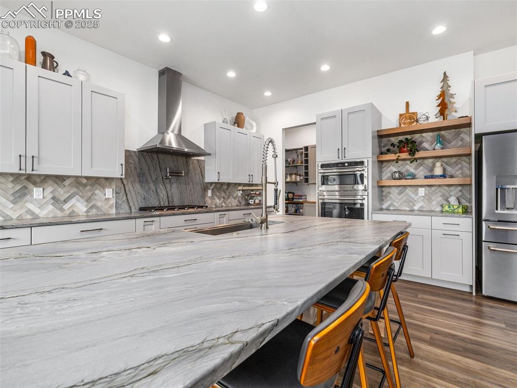5843 Hart Ranch Drive Beulah, CO 81023 - Photo 12 of 50 a kitchen with stainless steel appliances granite countertop a sink a stove white cabinets and wooden floor