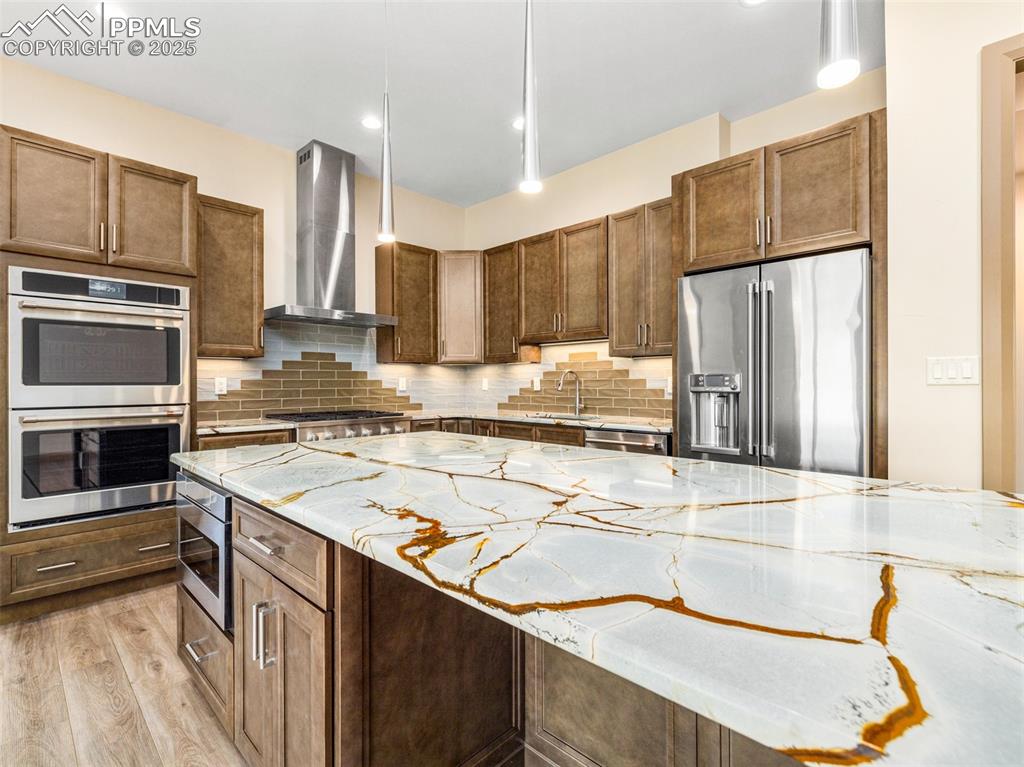 5843 Hart Ranch Drive Beulah, CO 81023 - Photo 39 of 50 a kitchen with stainless steel appliances granite countertop a sink a stove and a refrigerator with wooden floor
