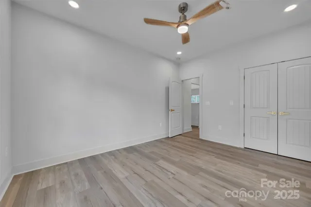 an empty room with fan and entrance