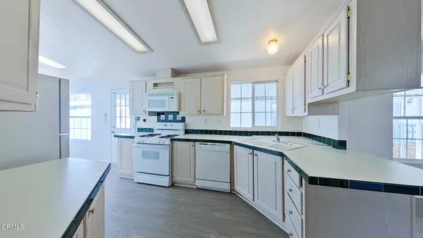 a kitchen with granite countertop a sink stove and cabinets