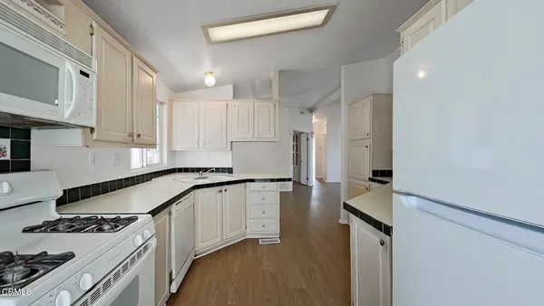 a kitchen with granite countertop a sink stove and refrigerator