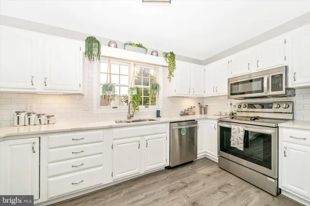 a kitchen with granite countertop a stove top oven microwave and refrigerator