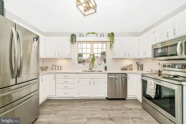 a kitchen with granite countertop white cabinets and stainless steel appliances
