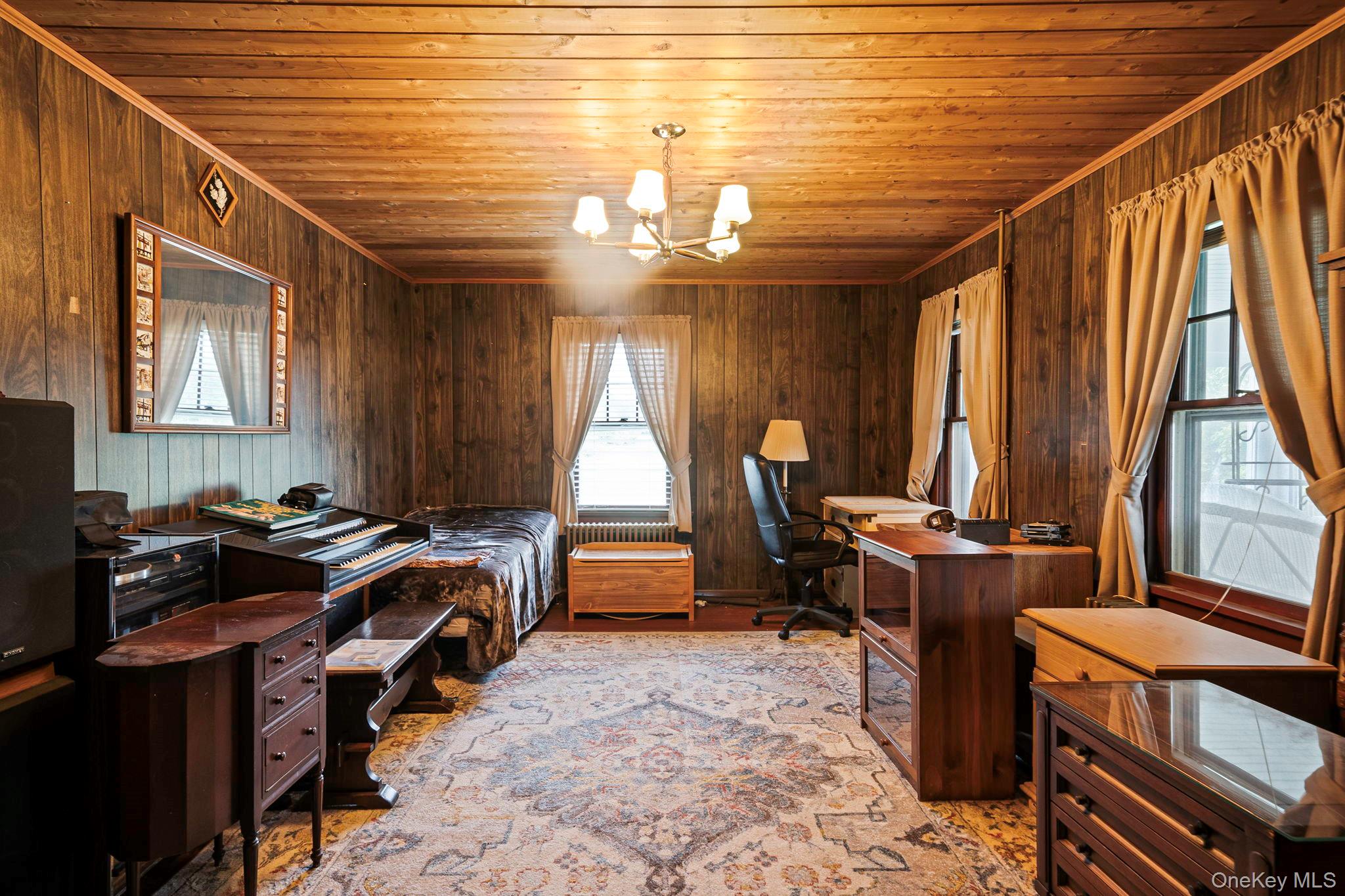 1055 Oregon Road Mattituck, NY 11952 - Photo 17 of 33 Wood-paneled room featuring a wood-finish plank ceiling, multiple windows and a chandelier