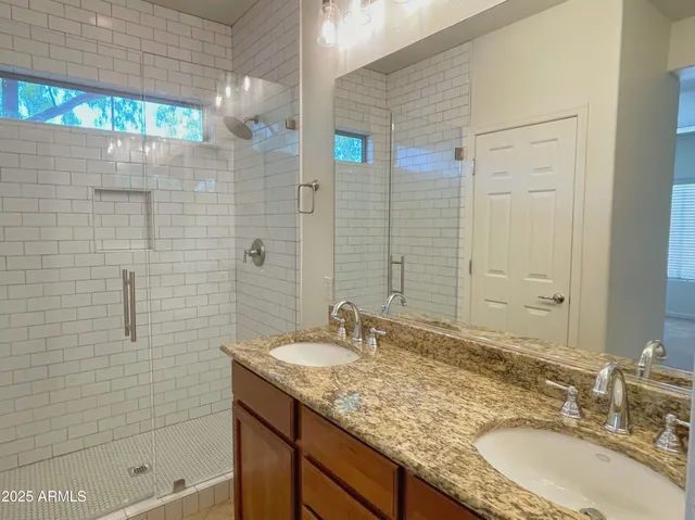 a bathroom with a granite countertop sink a shower and a mirror