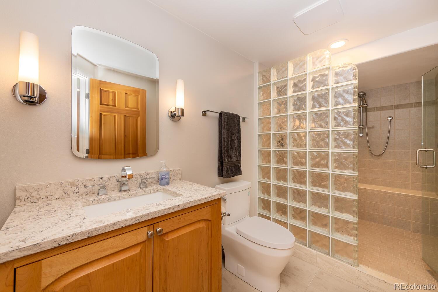 3828 Cloverleaf Drive Boulder, CO 80304 - Photo 30 of 40 a bathroom with a granite countertop toilet sink and mirror