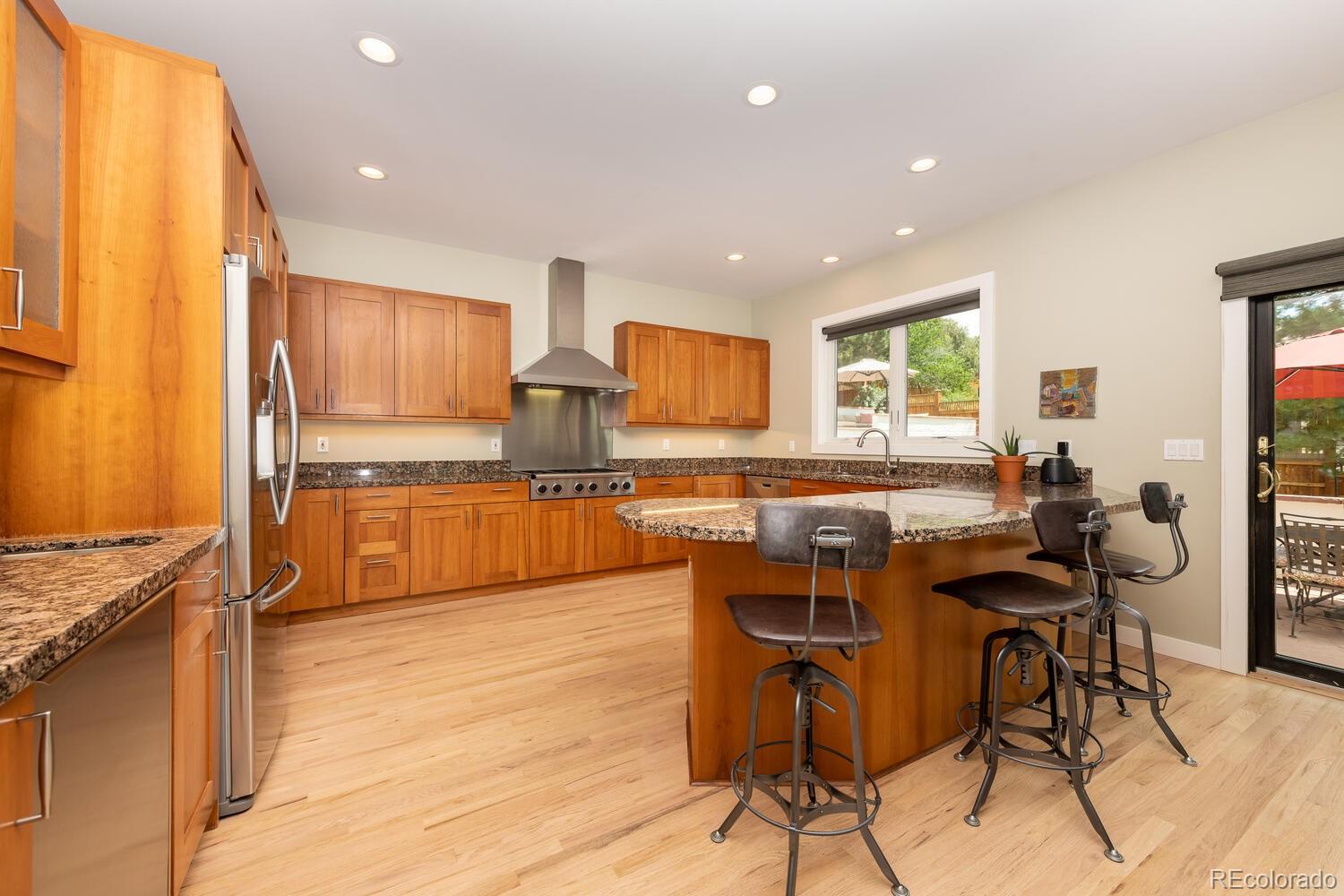 3828 Cloverleaf Drive Boulder, CO 80304 - Photo 10 of 40 a kitchen with stainless steel appliances kitchen island granite countertop a table chairs and a refrigerator