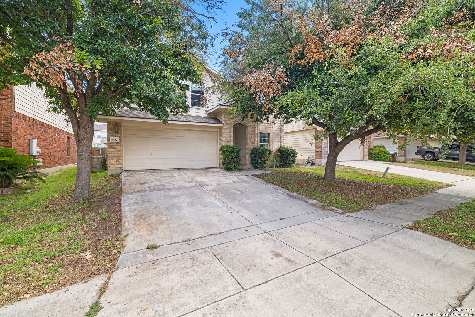 a front view of a house with a yard and trees