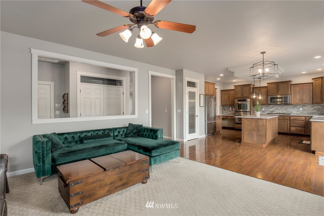 5805 Parker Road East Sumner, WA 98390 - Photo 22 of 40 a living room with kitchen island furniture and a chandelier