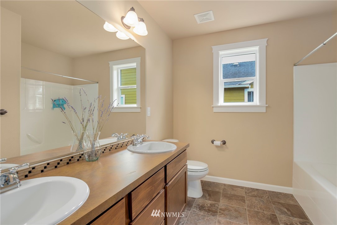 5805 Parker Road East Sumner, WA 98390 - Photo 36 of 40 a bathroom with a granite countertop sink toilet and a mirror