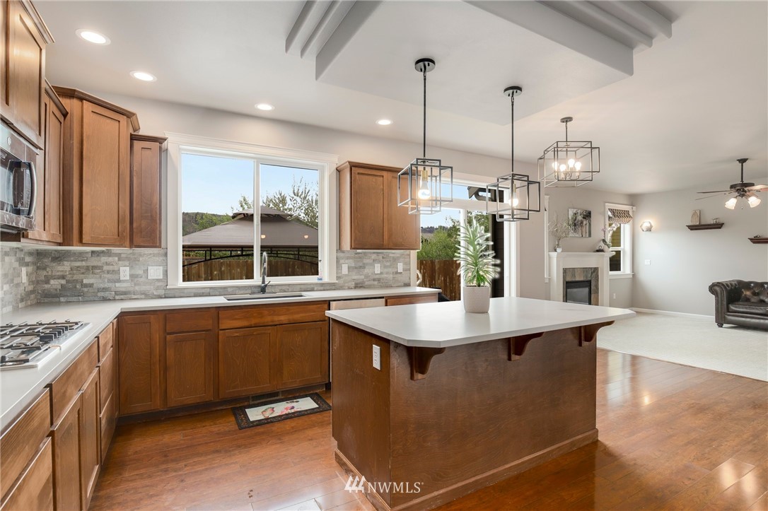 5805 Parker Road East Sumner, WA 98390 - Photo 10 of 40 a kitchen with stainless steel appliances granite countertop a sink a stove and a wooden floors