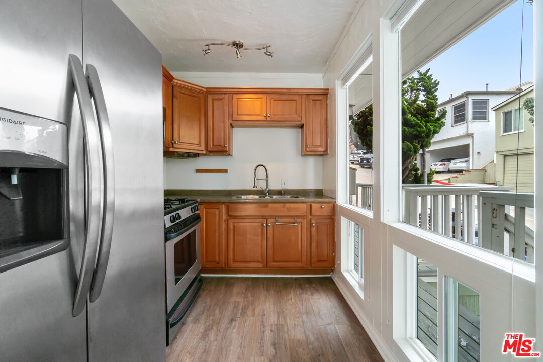 115 44th Street Manhattan Beach, CA 90266 - Photo 17 of 38 a kitchen with stainless steel appliances granite countertop a refrigerator a sink and wooden floors