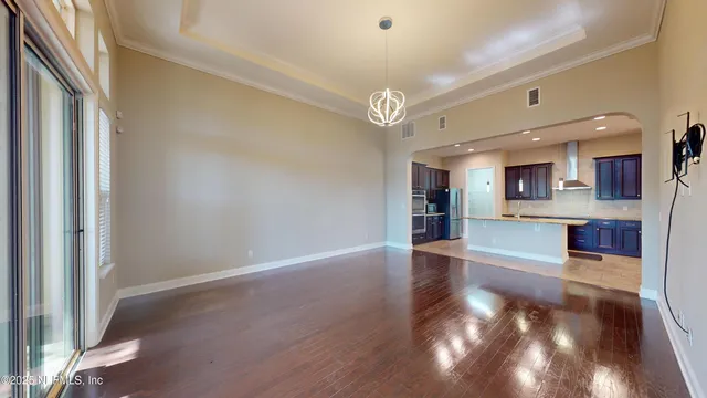 a view of a kitchen with wooden floor and a refrigerator
