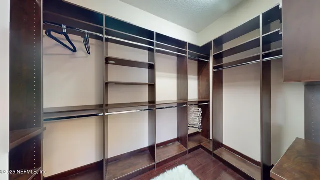 a view of walk in closet with empty racks