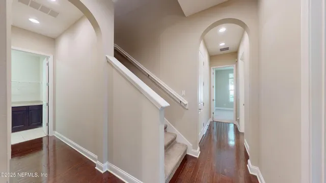 a view of a hallway with wooden floor and staircase