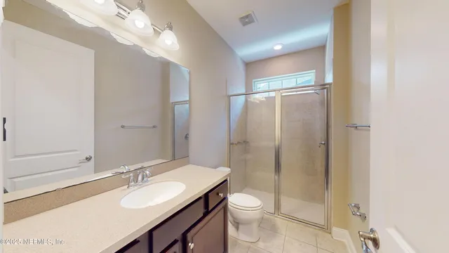 a bathroom with a granite countertop sink toilet a mirror and shower