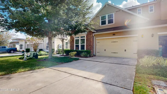 a front view of a house with a garden and trees
