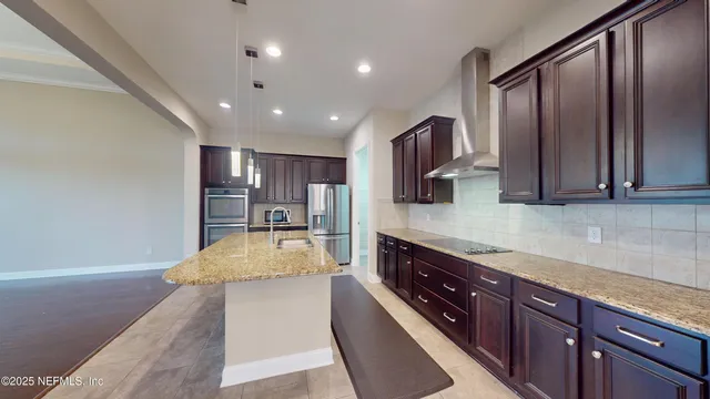 a large kitchen with stainless steel appliances granite countertop plenty wooden cabinets counter space and a sink