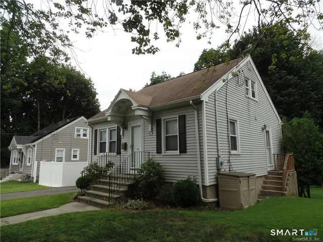 a front view of a house with a garden and plants