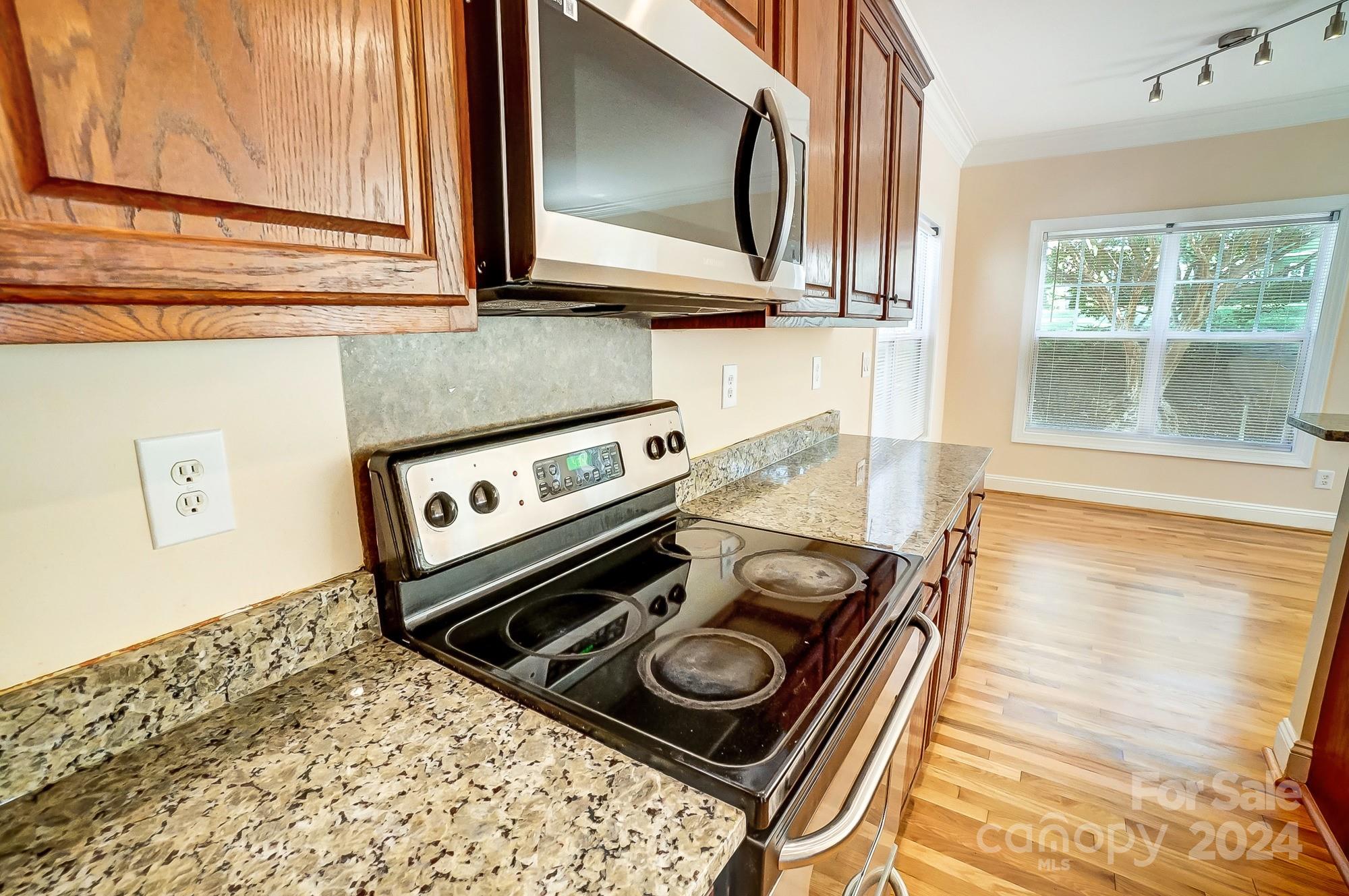 14137 Wild Elm Road Charlotte, NC 28277 - Photo 12 of 36 a stove top oven sitting next to a window
