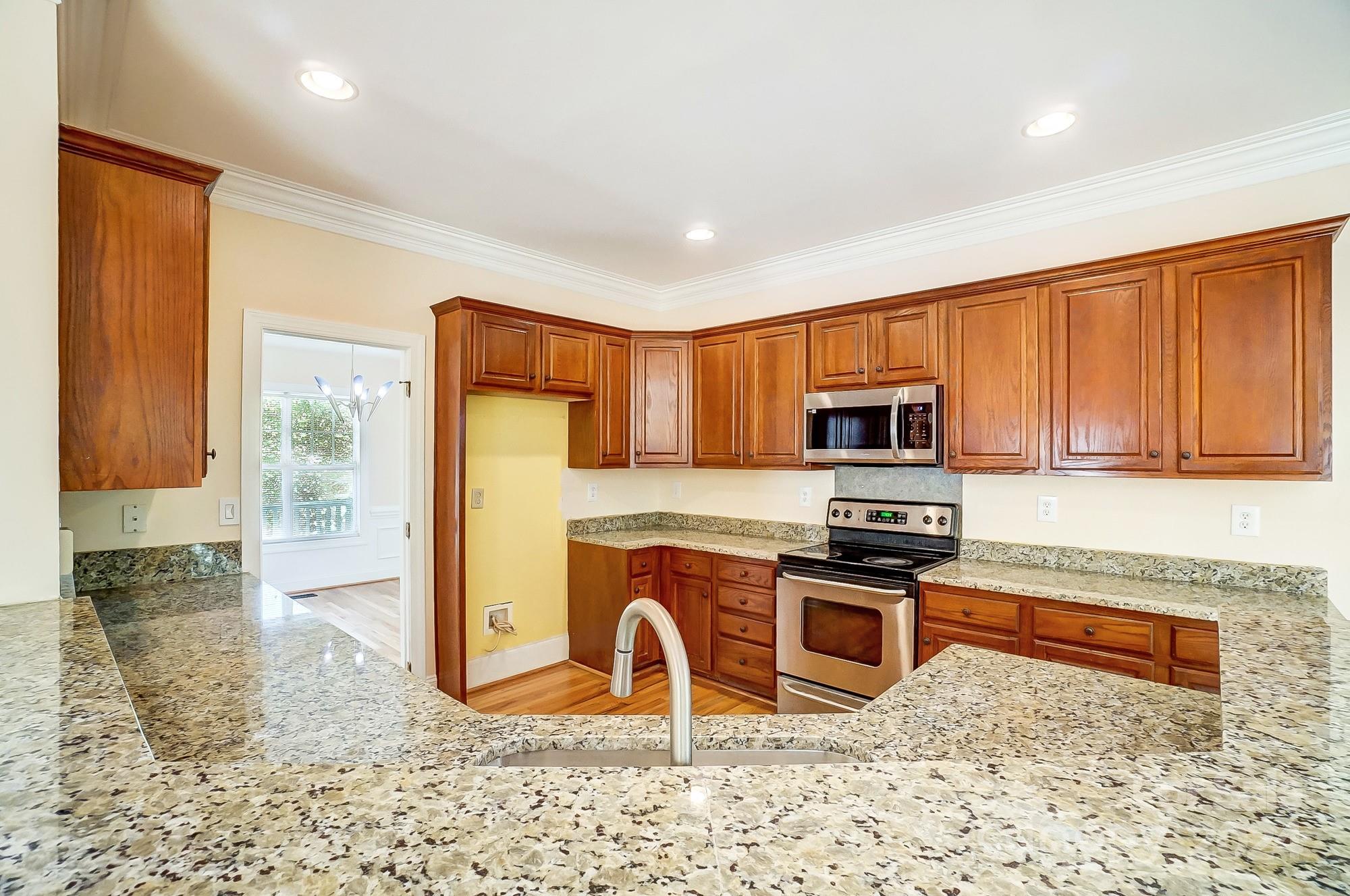 14137 Wild Elm Road Charlotte, NC 28277 - Photo 14 of 36 a kitchen with stainless steel appliances granite countertop a refrigerator a stove top oven a sink and dishwasher