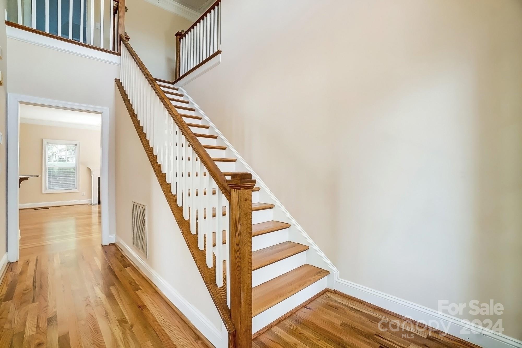 14137 Wild Elm Road Charlotte, NC 28277 - Photo 18 of 36 a view of staircase with lots of frames on wall and wooden floor