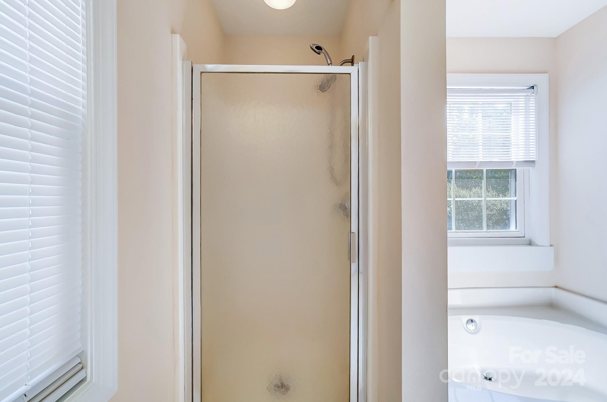 14137 Wild Elm Road Charlotte, NC 28277 - Photo 25 of 36 a bathroom with a glass shower door