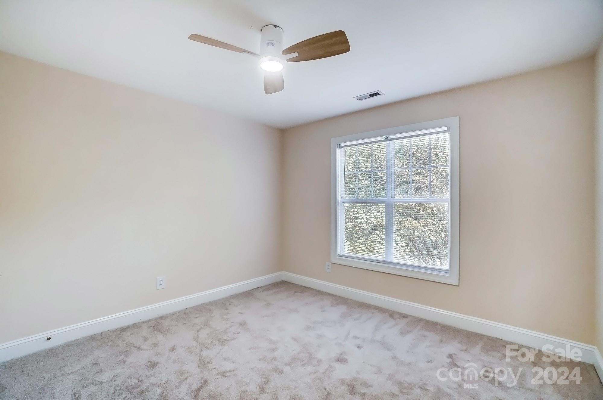14137 Wild Elm Road Charlotte, NC 28277 - Photo 27 of 36 an empty room with a window and a ceiling fan
