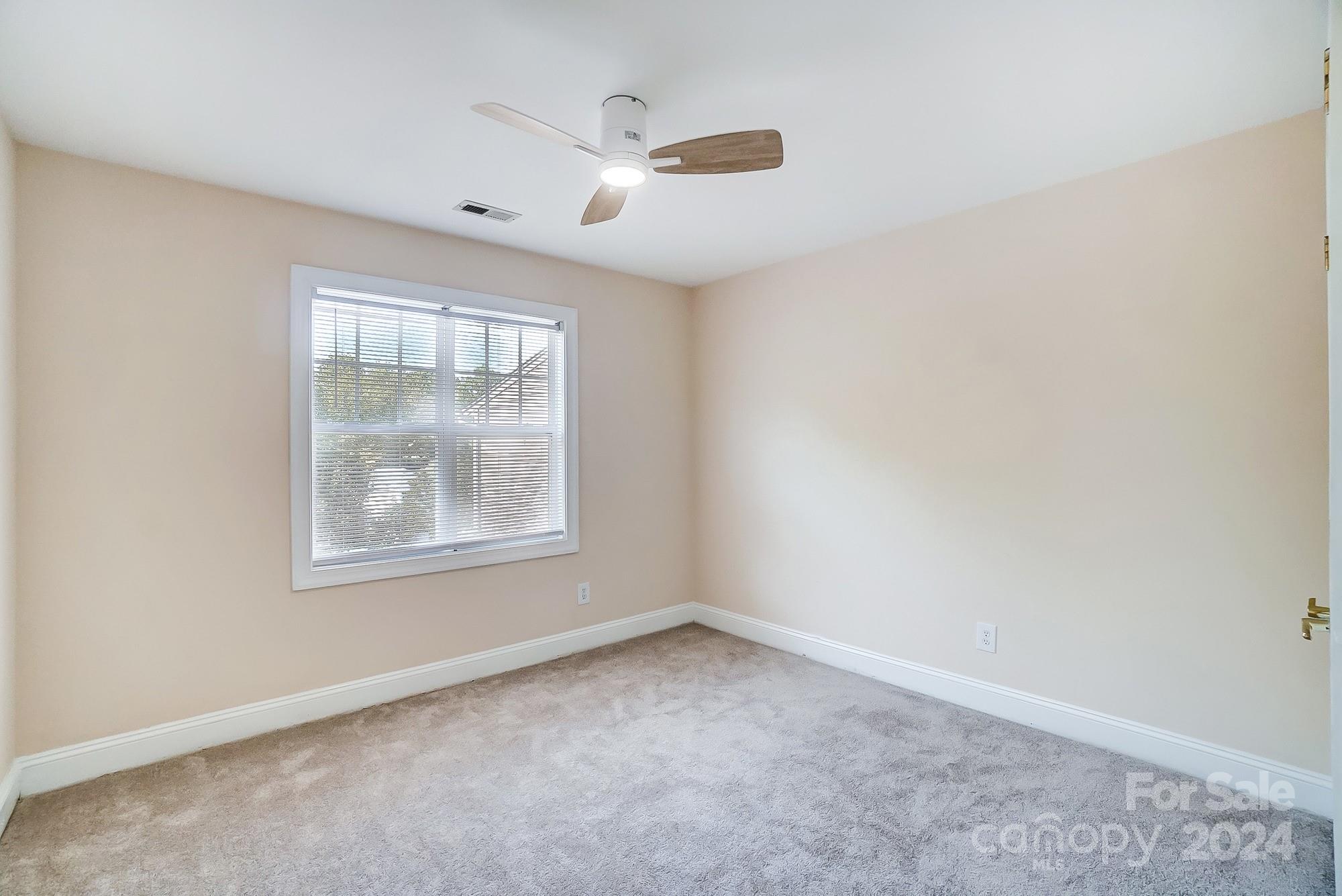 14137 Wild Elm Road Charlotte, NC 28277 - Photo 28 of 36 an empty room with a window and a ceiling fan
