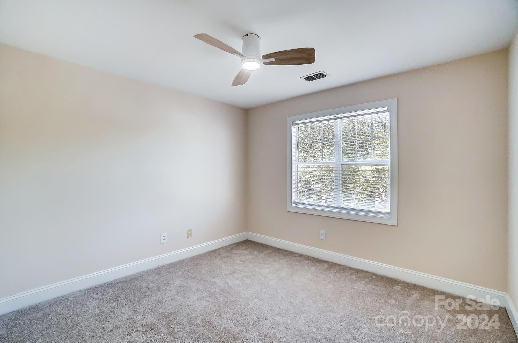 14137 Wild Elm Road Charlotte, NC 28277 - Photo 31 of 36 an empty room with ceiling fan and windows