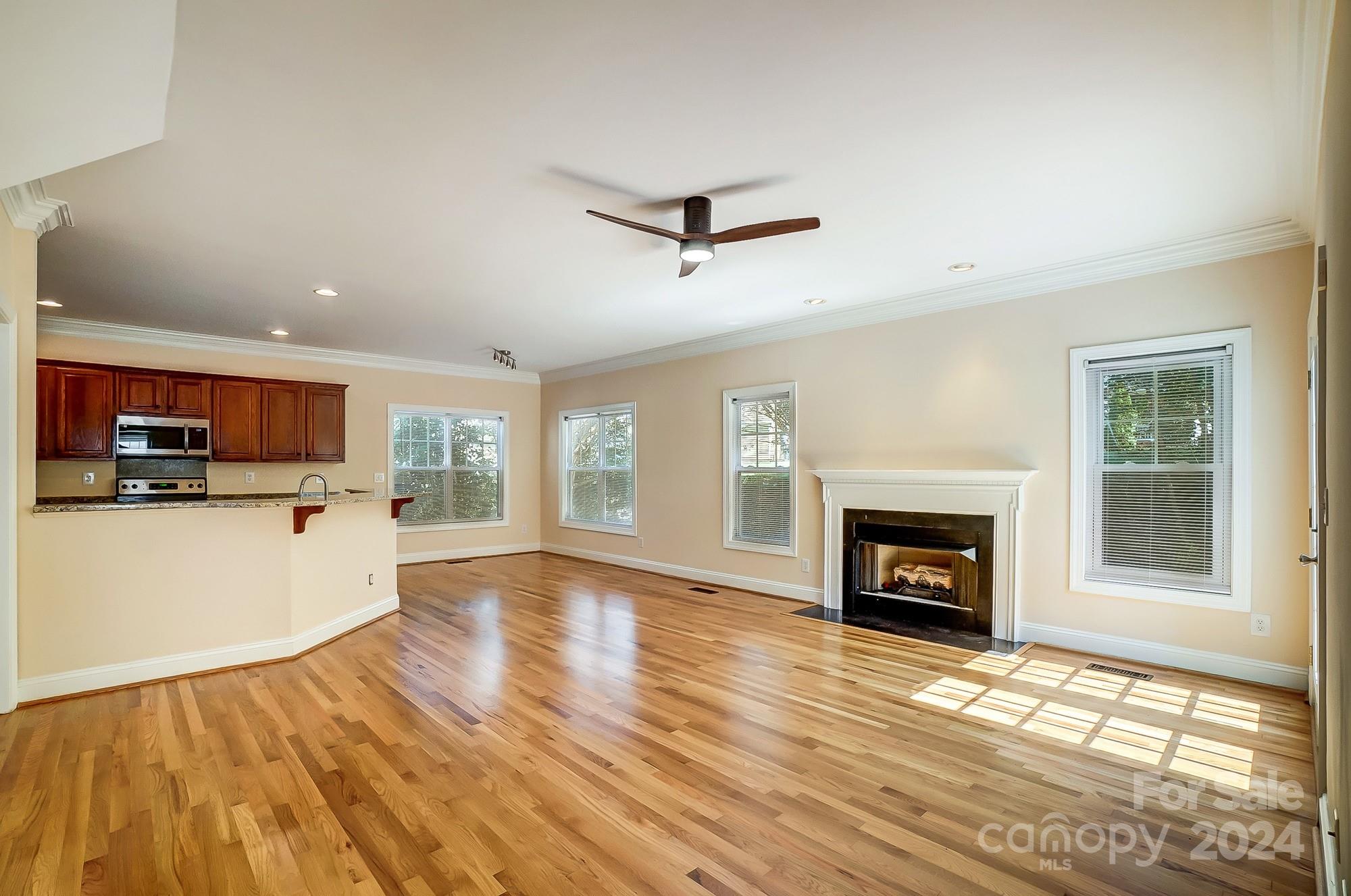 14137 Wild Elm Road Charlotte, NC 28277 - Photo 6 of 36 a living room with stainless steel appliances furniture a fireplace and a kitchen view