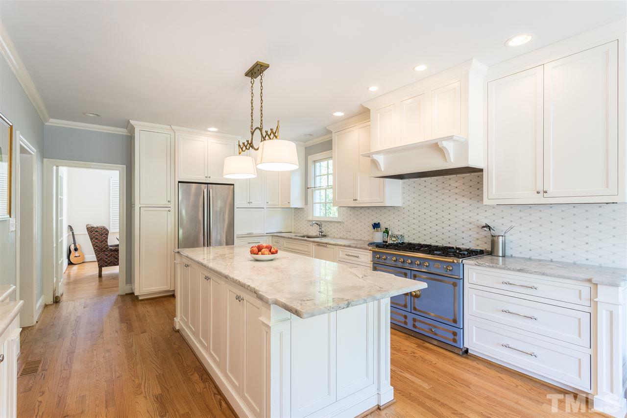 1424 Canterbury Road Raleigh, NC 27608 - Photo 11 of 29 a kitchen that has a lot of cabinets in it and wooden floors