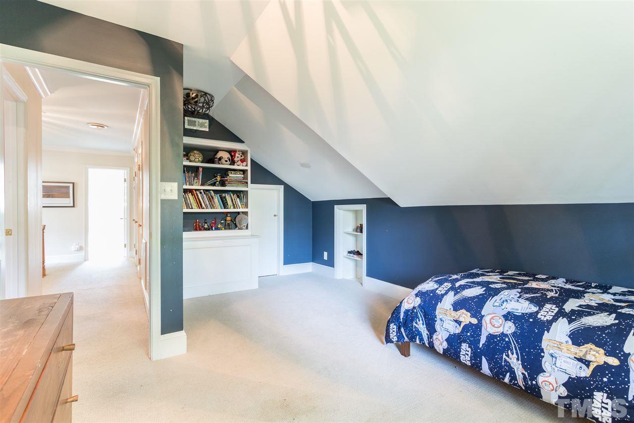 1424 Canterbury Road Raleigh, NC 27608 - Photo 25 of 29 a bedroom with a large bed and a chandelier