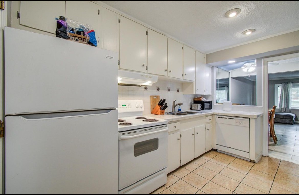 11609 Chimney Rock Road, Unit B Houston, TX 77035 - Photo 8 of 22 a kitchen with white cabinets and white appliances
