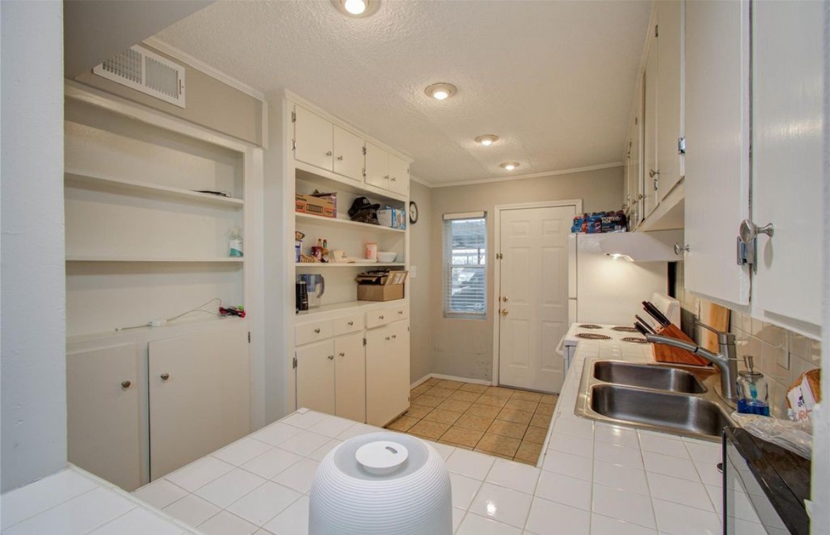 11609 Chimney Rock Road, Unit B Houston, TX 77035 - Photo 10 of 22 a kitchen with a refrigerator and white cabinets