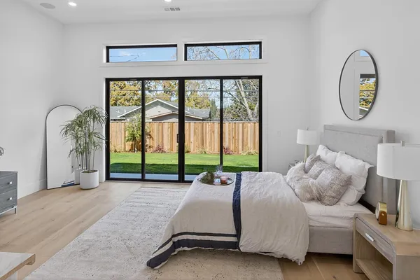 a spacious bedroom with a bed a couch and a large window
