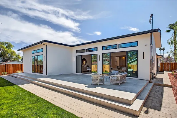 a backyard of a house with barbeque oven table and chairs