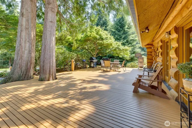 a view of a patio with table and chairs with wooden floor and fence
