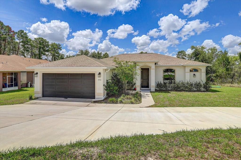 7314 Madrid Road Weeki Wachee, FL 34613 - Photo 37 of 54 a front view of a house with garden
