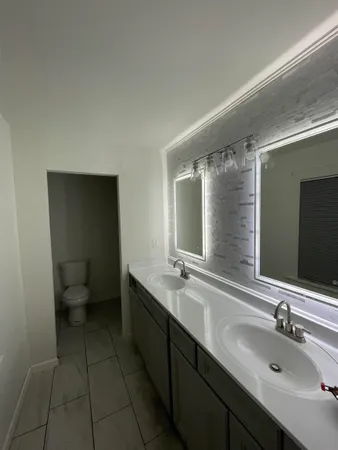 a bathroom with a double vanity sink and mirror