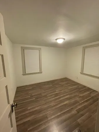 a view of a room with wooden floor and windows