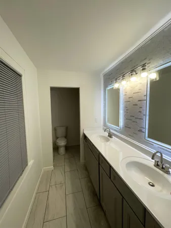 a bathroom with a double vanity sink and a mirror